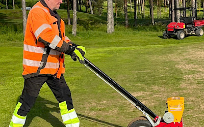 Kentänhoitajamme Arto työntää käsikäyttöistä rivikylvökonetta.