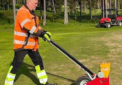Kentänhoitajamme Arto työntää käsikäyttöistä rivikylvökonetta.